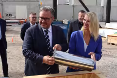 Suomen ympäristö- ja ilmastoministeri Sari Multala ja opetus- ja kulttuuriministeriön ylijohtaja Juha Rintamäki asettavat aikakapselin peruskiveen muurattavaksi. 